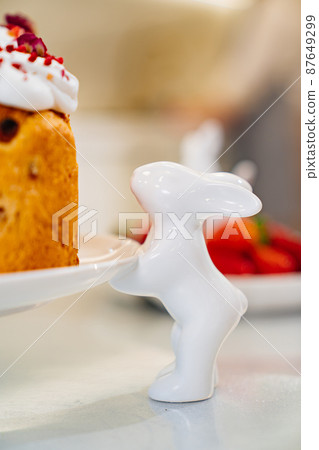 part of decorated panettone on serving plate with rabbits. easter cakes. part of decorated panettone on serving plate with rabbits. easter cakes. 87649299