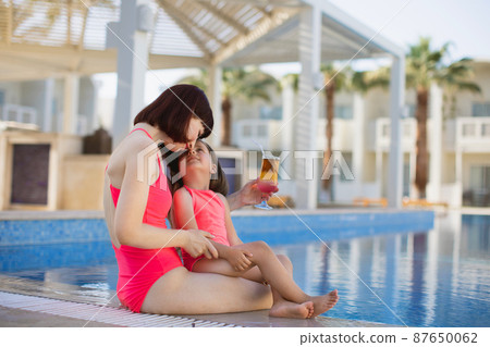 Happy family in the pool, having fun, mother with baby girl on summer holidays vacation. Happy family in the pool, having fun, mother with baby girl on summer holidays vacation. 87650062