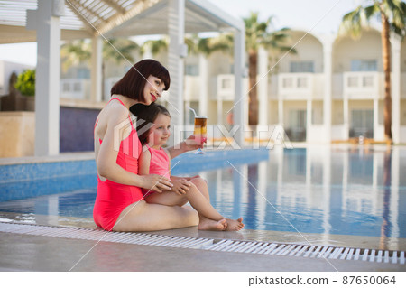 Happy family in the pool, having fun, mother with baby girl on summer holidays vacation. Happy family in the pool, having fun, mother with baby girl on summer holidays vacation. 87650064