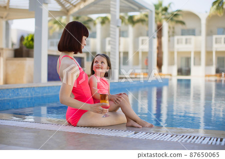 Happy family in the pool, having fun, mother with baby girl on summer holidays vacation. Happy family in the pool, having fun, mother with baby girl on summer holidays vacation. 87650065