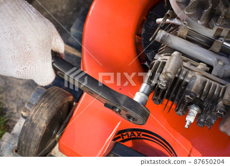 Repairing a lawn mower. Repairing lawn mower engine. Repairing a lawn mower. Repairing lawn mower engine. 87650204