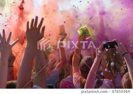 Festival of Colours - holi. Mass event, colored powder. Raised hands up. Festival of Colours - holi. Mass event, colored powder. Raised hands up. 87650364