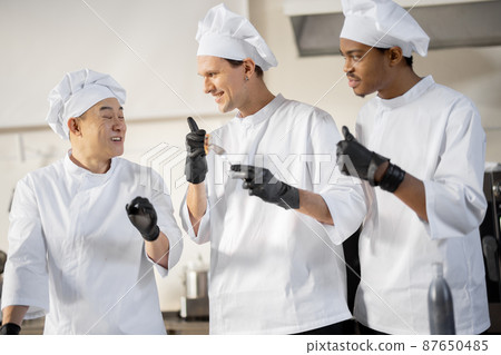 Cooks with different nationalties tasting cooked meals for restaurant menu 87650485