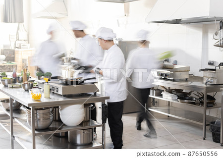 Chef cooks working in professional kitchen Chef cooks working in professional kitchen 87650556
