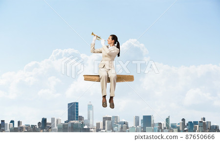 Elegant woman in business suit sitting on book Elegant woman in business suit sitting on book 87650666
