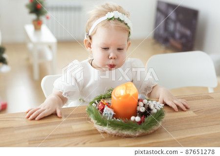 Baby child with hearing aids and cochlear implants plays with candle. Deaf and health concept Baby child with hearing aids and cochlear implants plays with candle. Deaf and health concept 87651278