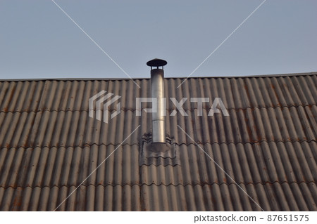 Chimney metal pipe home stove on the roof of the house 87651575