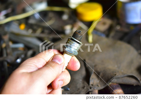 Car spark plug in hand in the garage Car spark plug in hand in the garage 87652260