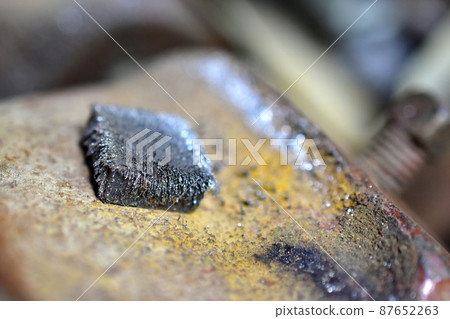 Metal magnet in the iron crumb in the hands 87652263