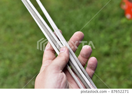 Welding electrodes in hands on a background of grass 87652271