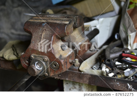 Red massive locksmith iron vise on an iron table 87652275