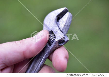 A small shiny wrench in the hands of the master A small shiny wrench in the hands of the master 87652279