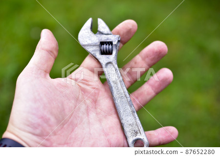 A small shiny wrench in the hands of the master A small shiny wrench in the hands of the master 87652280