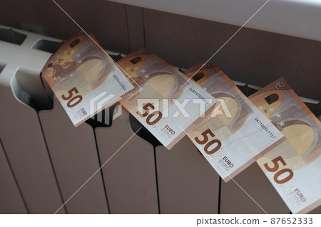 banknotes of 50 euros lie on the radiator of the heating system, the cost of heat banknotes of 50 euros lie on the radiator of the heating system, the cost of heat 87652333