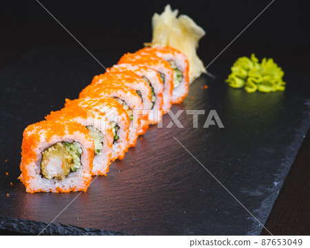 Traditional delicious fresh sushi roll set on a black background