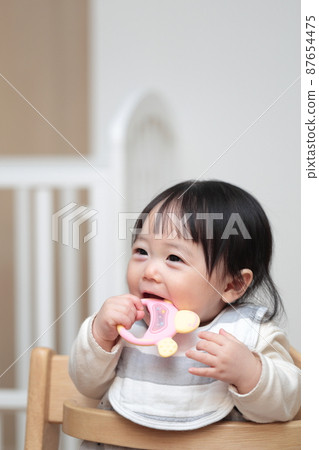 A 10-month-old baby playing with a toy that hardens his teeth A 10-month-old baby playing with a toy that hardens his teeth 87654475