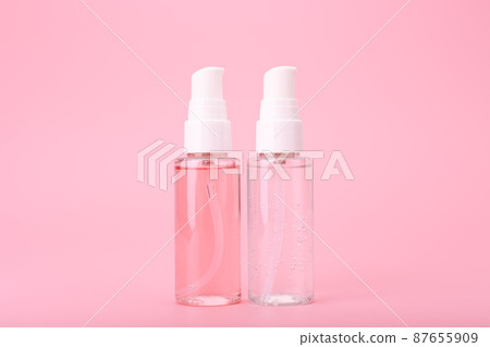 Two different face lotion, liquid foam or gel for skin cleaning in transparent tubes on bright pink background Two different face lotion, liquid foam or gel for skin cleaning in transparent tubes on bright pink background 87655909