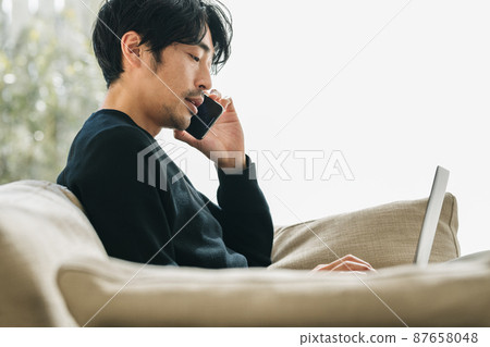 A man calling in the living room A man calling in the living room 87658048