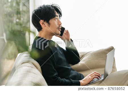 一個人在客廳裡做遠程辦公 87658052
