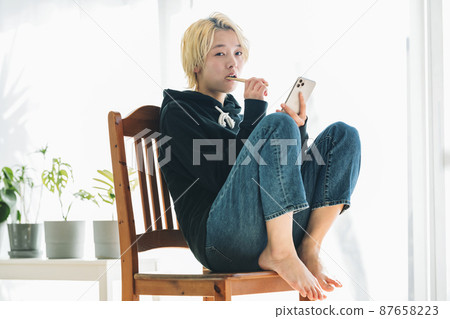 一個拿著智能手機刷牙的女人 一個拿著智能手機刷牙的女人 87658223