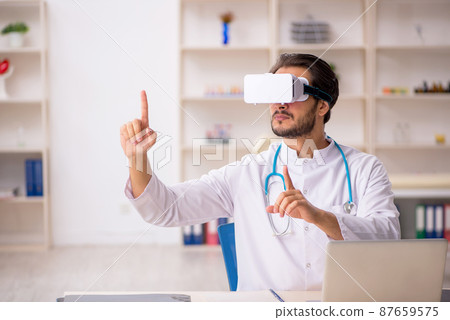 Young male doctor wearing virtual glasses Young male doctor wearing virtual glasses 87659575