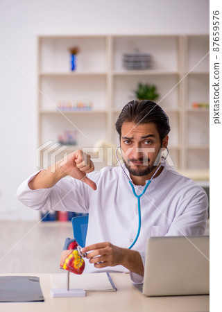 Young male doctor cardiologist working in the clinic Young male doctor cardiologist working in the clinic 87659576