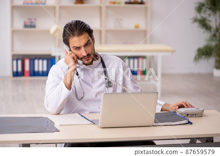 Young male doctor in telemedicine concept Young male doctor in telemedicine concept 87659579
