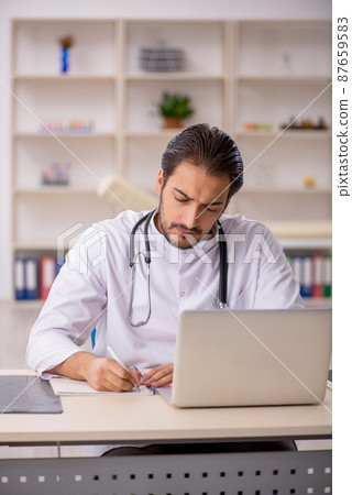 Young male doctor working in the clinic 87659583