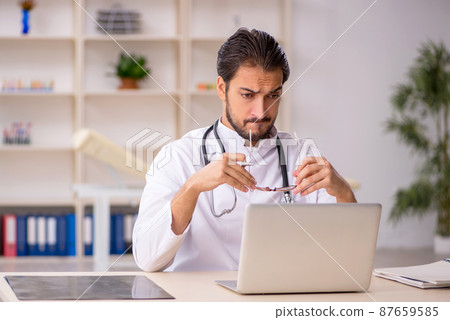 Young male doctor in telemedicine concept Young male doctor in telemedicine concept 87659585