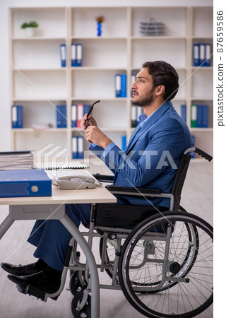 Young male employee in wheel-chair sitting in the office 87659586