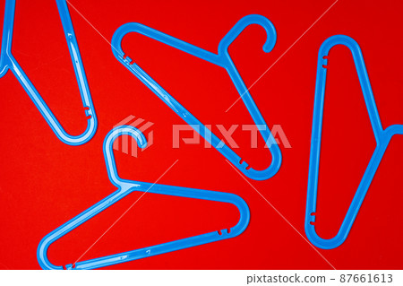 Hanger on red paper background. Minimalistic fashion concept. Top view Hanger on red paper background. Minimalistic fashion concept. Top view 87661613