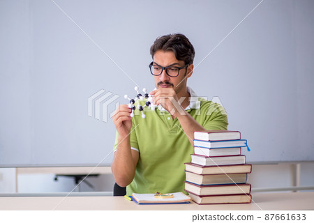 Young male student chemist preparing for exams in the classroom 87661633