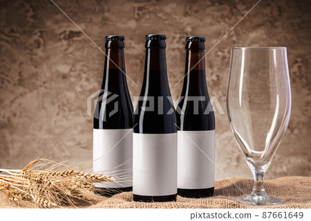 Beer bottle and beer glass against gray background Beer bottle and beer glass against gray background 87661649