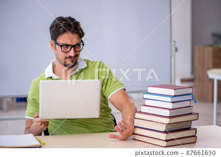 Young male student preparing for exams in the classroom Young male student preparing for exams in the classroom 87661650