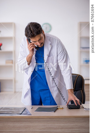 Young male doctor working in the clinic 87661694