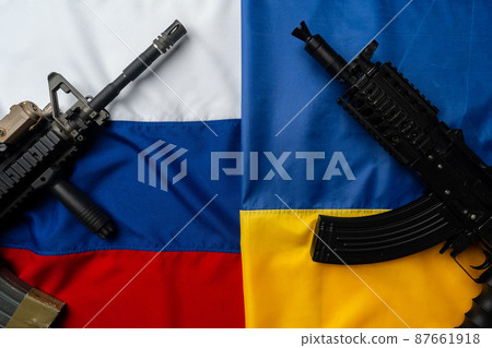 Flags of Russia and Ukraine folded together with rifle guns 87661918