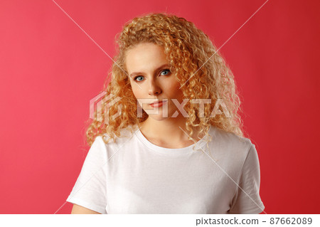 Gorgeous beautiful young woman with curly hair posing at camera 87662089