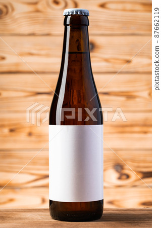Blank label on the beer bottle on wooden background. 87662119