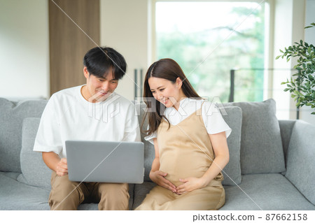Pregnant women and men looking at a computer (smiles) 87662158