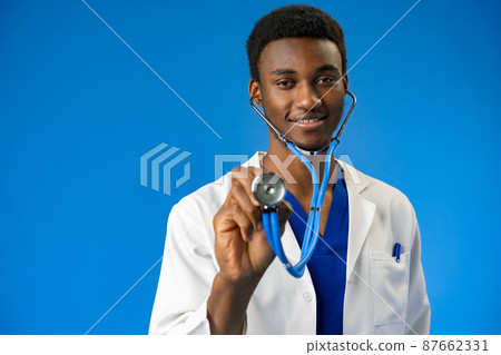 Confident black doctor posing over blue studio background. Confident black doctor posing over blue studio background. 87662331