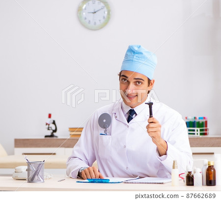 Young male doctor otolaryngologist working at the hospital 87662689