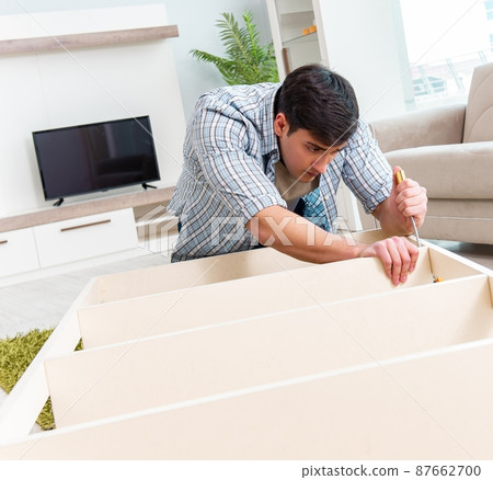 Man assembling furniture at home Man assembling furniture at home 87662700