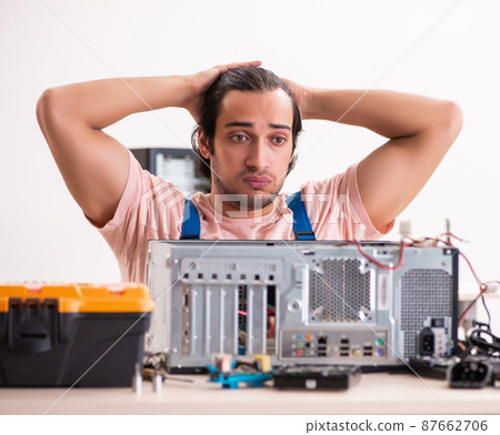 The young male contractor repairing computer The young male contractor repairing computer 87662706