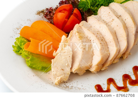 Pieces of boiled chicken breast with vegetables over white background Pieces of boiled chicken breast with vegetables over white background 87662708