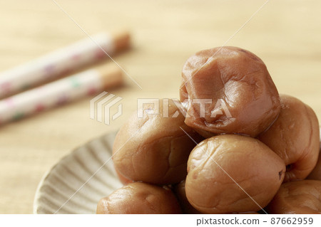 Handmade pickled plums on a pottery plate 87662959