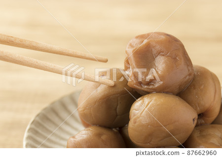 Handmade pickled plums on a pottery plate Handmade pickled plums on a pottery plate 87662960