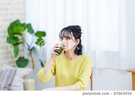 為健康喝綠汁的年輕女子 為健康喝綠汁的年輕女子 87663050