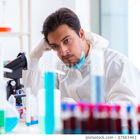 Young chemist student working in lab on chemicals Young chemist student working in lab on chemicals 87663461