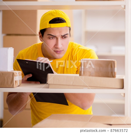Man working in postal parcel delivery service office Man working in postal parcel delivery service office 87663572
