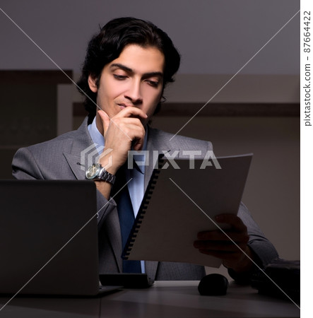 The young handsome employee and too much work in the office 87664422